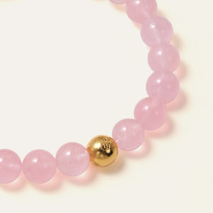 Close-up of vibrant AAA Madagascar Rose Quartz beads showing jelly-like translucency, paired with the Soul Lykke 14K gold PVD steel bead.