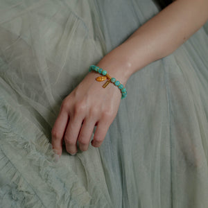 A woman wearing the dainty 7mm icy amazonite healing bracelet gracefully on her wrist. Revered as the Stone of Courage and Truth, this elegant crystal jewelry piece is designed to quiet mental noise and restore confidence.