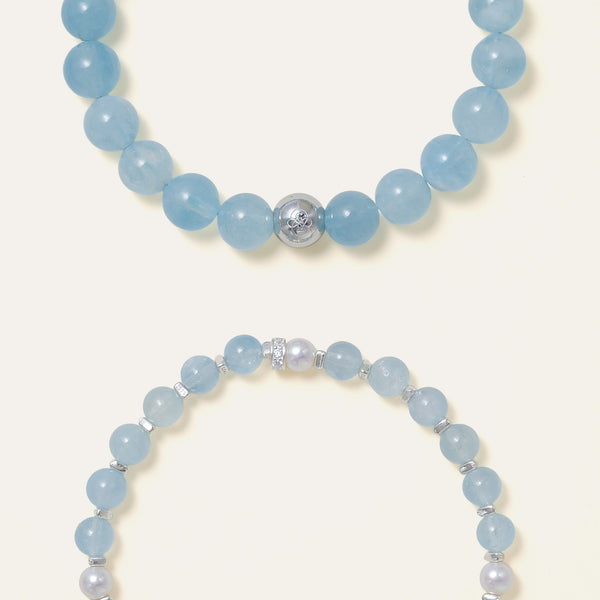 Detailed view of stacked Soul Lykke bracelets, contrasting the 8mm oceanic Aquamarine beads with smaller gems and a lustrous pearl accent.