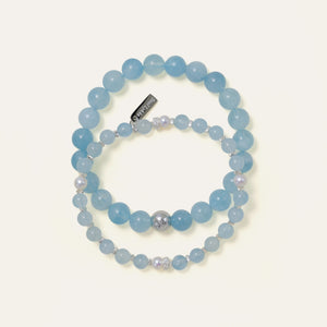 Soul Lykke Core Essential Aquamarine bracelet stacked with a delicate gemstone and pearl design, highlighting the brand's signature engraved tag.