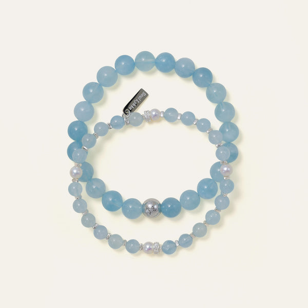 Soul Lykke Core Essential Aquamarine bracelet stacked with a delicate gemstone and pearl design, highlighting the brand's signature engraved tag.