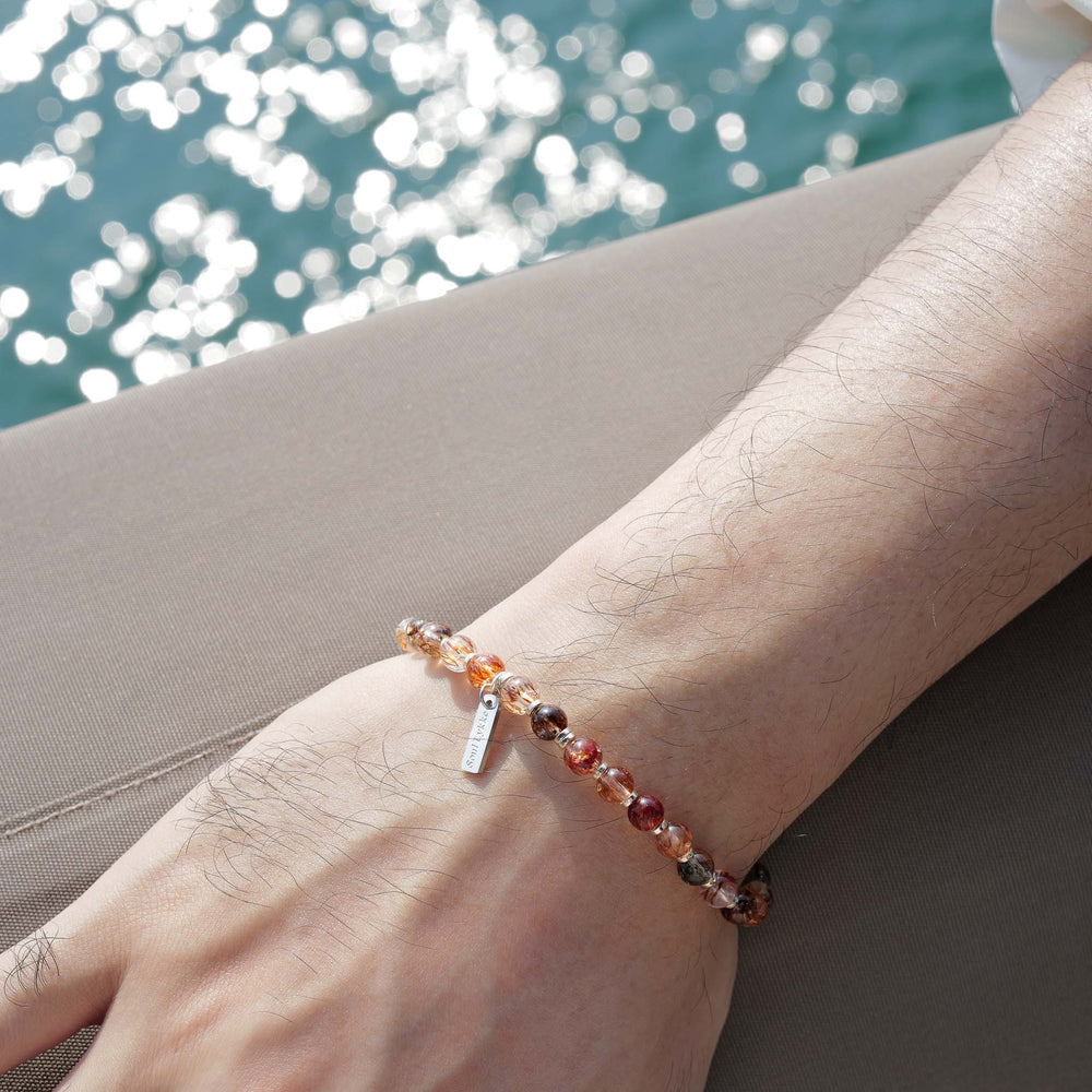 Top-down view of the Soul Lykke Shadow Gold bracelet, featuring glass-clear 6mm AAA+ Black Gold Super Seven beads and a White Gold tag. This is a natural gemstone and healing crystal bracelet by Soul Lykke.