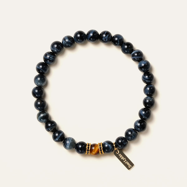 8mm natural Blue Tiger's Eye beaded bracelet featuring a golden Tiger's Eye center stone and a gold Soul Lykke tag. This is a natural gemstone and healing crystal bracelet by Soul Lykke.
