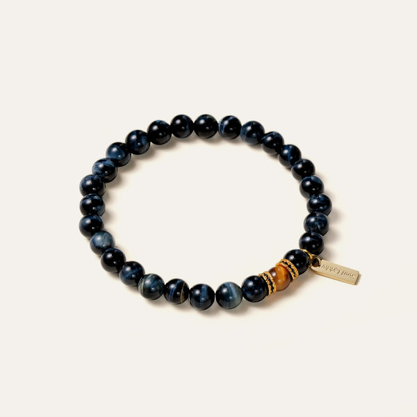 Close-up of Blue Tiger's Eye gemstone bracelet with black and gold textured spacer beads.