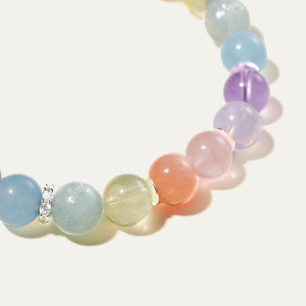 Close-up detail of natural AAA-grade Peach Moonstone and luminous Prehnite beads. The crystalline transparency of these pastel gemstones reveals delicate asterism and chatoyancy when touched by light, framed by sterling silver wafers.