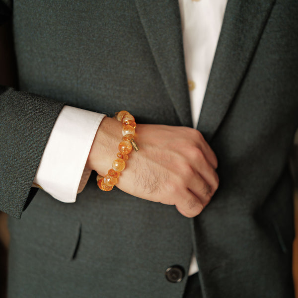 Executive styling of a bold 12mm Golden Phantom Citrine bracelet with a dark suit, worn as a Solar Plexus master stone for career abundance.