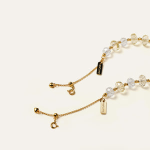 Close-up of the 24K gold-plated adjustable chain and the engraved Soul Lykke signature tag on a gemstone bracelet.