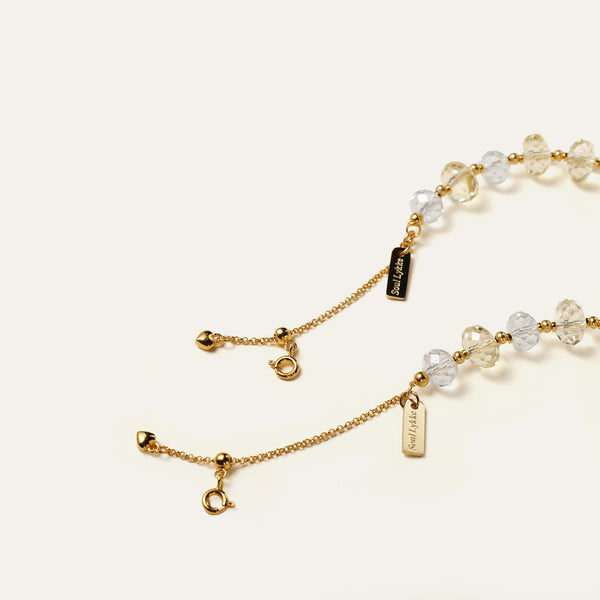 Close-up of the 24K gold-plated adjustable chain and the engraved Soul Lykke signature tag on a gemstone bracelet.