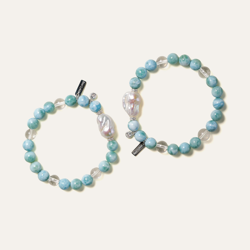 The Marine Veil bracelet by Soul Lykke, featuring an authentic 20mm East Asian baroque pearl centerpiece, surrounded by 8mm AA grade Dominican Larimar, clear quartz, and 925 sterling silver CZ spacers on a neutral background. This is a natural gemstone and healing crystal bracelet by Soul Lykke.