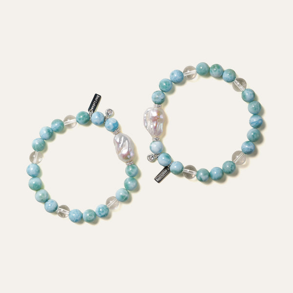 Two handmade Larimar and baroque pearl bracelets placed side-by-side, illustrating the one-of-a-kind organic silhouette of each natural pearl. Designed to balance the Throat and Crown Chakras with tranquil energy.
