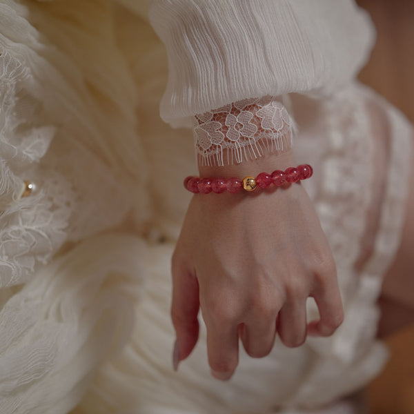 A woman gracefully wearing the 8mm natural star strawberry quartz healing bracelet. Aligned with the Heart Chakra, this high-vibrational crystal jewelry is designed to nurture fulfilling love and personal magnetism.