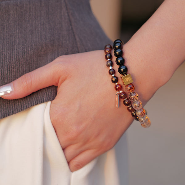 Model styling the Soul Lykke Eclipse Gold bracelet layered with Dusk & Dawn obsidian, featuring a 14K gold square signature bead.