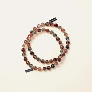 Two handcrafted Soul Lykke Black Gold Super Seven bracelets layered together, showcasing striking metallic blades and golden rutiles.