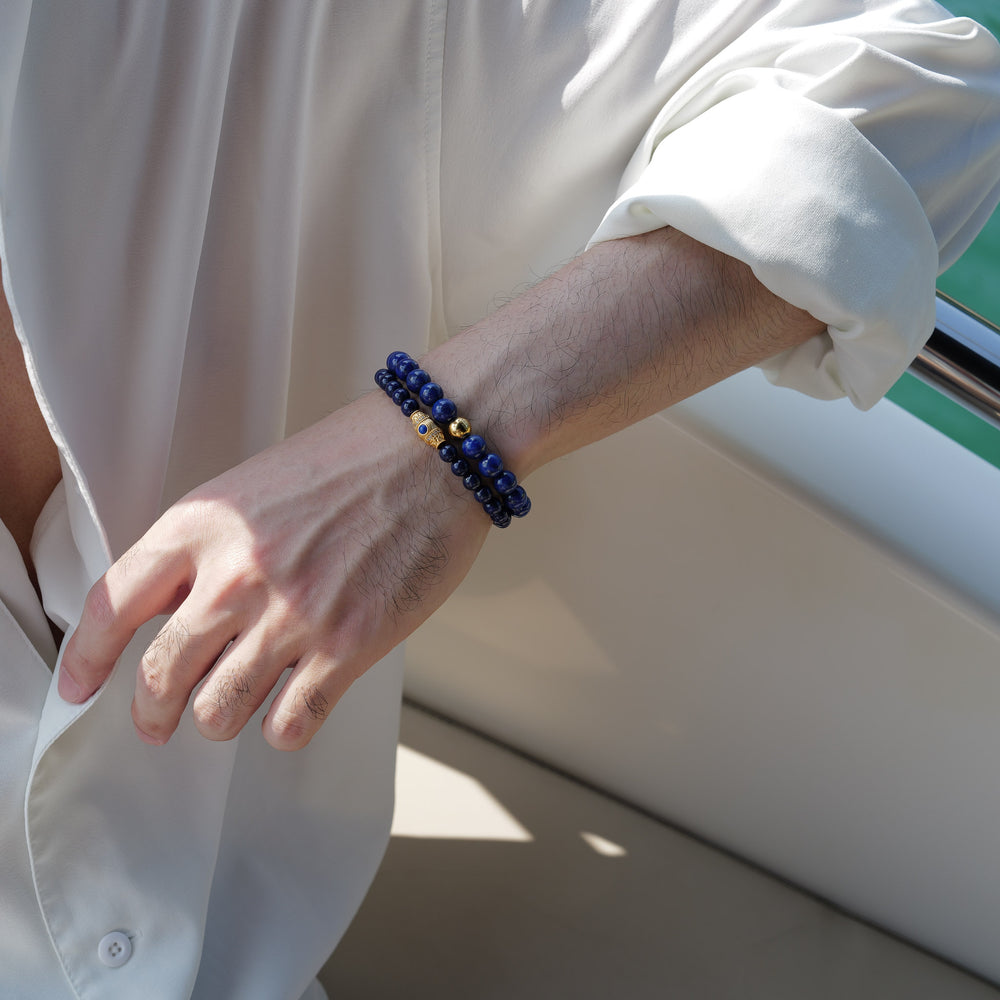 The Royal Vesper bracelet by Soul Lykke, featuring 6mm AAA-grade natural Afghan Lapis Lazuli. This luxury crystal jewelry showcases deep royal blue stones with golden pyrite flakes and an intricate pavé CZ gold barrel bead. This is a natural gemstone bracelet by Soul Lykke.