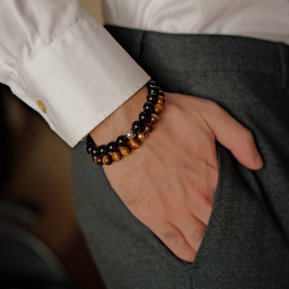 The Core Essential bracelet by Soul Lykke, featuring ethically sourced 8mm natural AAA Tiger's Eye beads from South Africa and a single engraved 14K gold PVD surgical steel signature bead on a seamless neutral background. This is a natural gemstone and healing crystal bracelet by Soul Lykke.