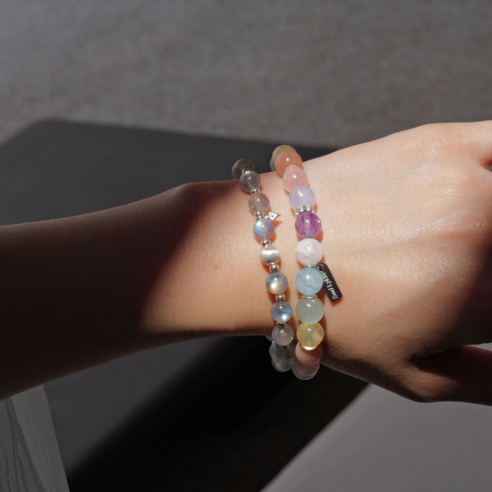 The Monet pastel multi-gemstone bracelet by Soul Lykke. A serene watercolor-inspired gradient featuring 8mm AAA-grade Hibiscus Rose Quartz, Teal Lepidolite, Aquamarine, and Lavender Amethyst on a seamless background. This is a healing crystal bracelet by Soul Lykke.