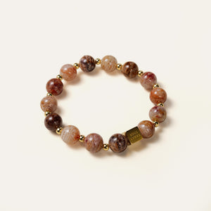 Close-up of AAA-grade natural Phantom Quartz beads, showcasing distinct layers of gray, orange, red, and brown mineral strata, paired with the Soul Lykke square bead.