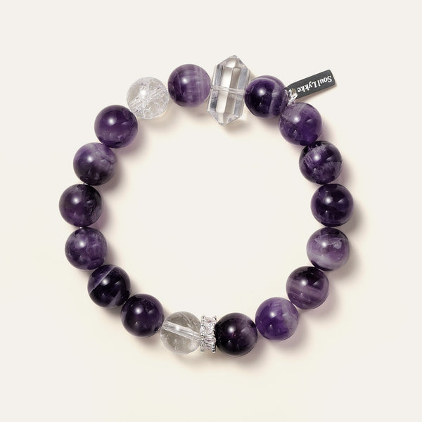 Lucid Dreamer bracelet featuring 10.5mm Dream Chevron Amethyst, a double-terminated clear quartz point, and the Soul Lykke signature white gold PVD tag. This is a natural gemstone and healing crystal bracelet by Soul Lykke.