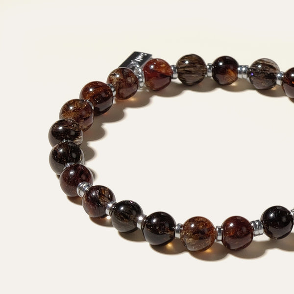 Close-up of AAA Black Gold Super Seven beads, revealing densely packed copper-red and gold mineral threads within crystal-clear quartz.