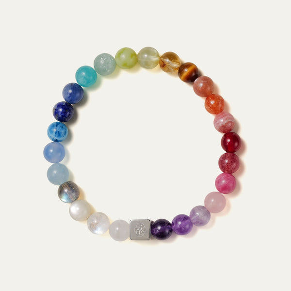 The Earth’s Palette flagship bracelet by Soul Lykke. A museum-grade wearable mineral collection featuring 25 distinct 8mm natural gemstones arranged in a seamless chromatic rainbow gradient, accented by a white gold PVD square signature bead. This is a healing crystal bracelet by Soul Lykke.