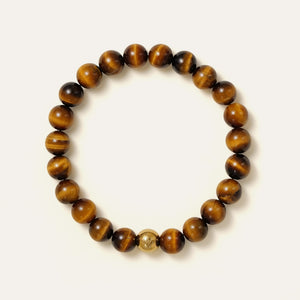 The Core Essential bracelet by Soul Lykke, featuring ethically sourced 8mm natural AAA Tiger's Eye beads from South Africa and a single engraved 14K gold PVD surgical steel signature bead on a seamless neutral background. This is a natural gemstone and healing crystal bracelet by Soul Lykke.