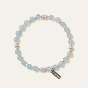 The Whispering Cove bracelet by Soul Lykke, featuring 6mm natural AAA Brazilian aquamarine and 5mm Japanese Akoya pearls with 925 sterling silver geometric spacers on a seamless background. This is a natural gemstone and healing crystal bracelet by Soul Lykke.