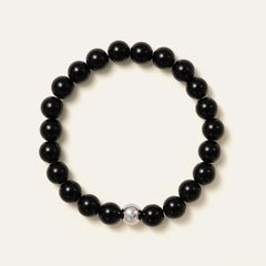 The Core Essential bracelet by Soul Lykke, featuring 8mm natural AAA black obsidian ethically sourced from Mexico, paired with a single hypoallergenic white gold PVD surgical steel signature bead. This is a natural gemstone and healing crystal bracelet by Soul Lykke.
