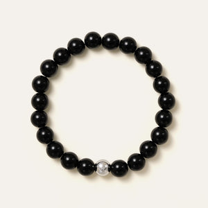 The Core Essential bracelet by Soul Lykke, featuring 8mm natural AAA black obsidian ethically sourced from Mexico, paired with a single hypoallergenic white gold PVD surgical steel signature bead. This is a natural gemstone and healing crystal bracelet by Soul Lykke.