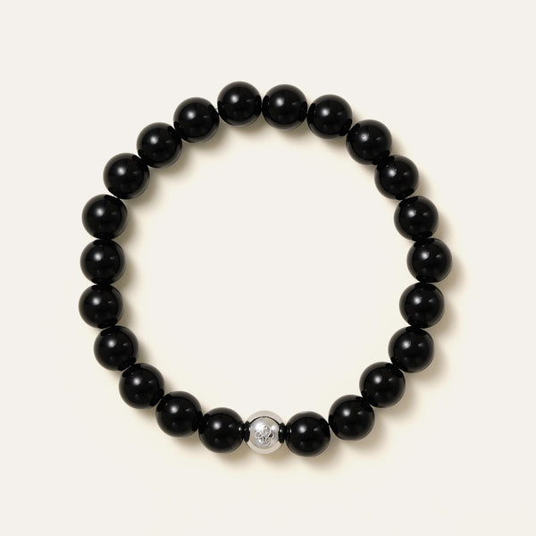 The Core Essential bracelet by Soul Lykke, featuring 8mm natural AAA black obsidian ethically sourced from Mexico, paired with a single hypoallergenic white gold PVD surgical steel signature bead. This is a natural gemstone and healing crystal bracelet by Soul Lykke.