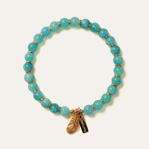 The Tide & Feather bracelet by Soul Lykke, featuring 7mm natural AAA Mozambique icy amazonite beads and a 24K gold-plated sculpted feather charm on a seamless neutral background. This is a natural gemstone and healing crystal bracelet by Soul Lykke.