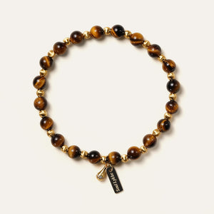 The Golden Glaze bracelet by Soul Lykke, featuring 6mm natural AAA South African Tiger's Eye beads and a delicate 24K gold-plated teardrop charm on a neutral background. This is a natural gemstone and healing crystal bracelet by Soul Lykke.