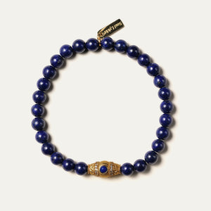The Royal Vesper bracelet by Soul Lykke, featuring 6mm AAA-grade natural Afghan Lapis Lazuli. This luxury crystal jewelry showcases deep royal blue stones with golden pyrite flakes and an intricate pavé CZ gold barrel bead. This is a natural gemstone bracelet by Soul Lykke.