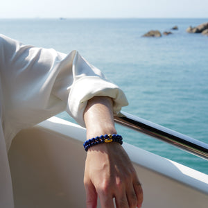 Sophisticated men's styling featuring a layered stack of natural AAA-grade Afghan Lapis Lazuli bracelets. The deeply saturated royal blue stones evoke a pristine night sky, empowering the wearer with intellectual sovereignty and clear expression.
