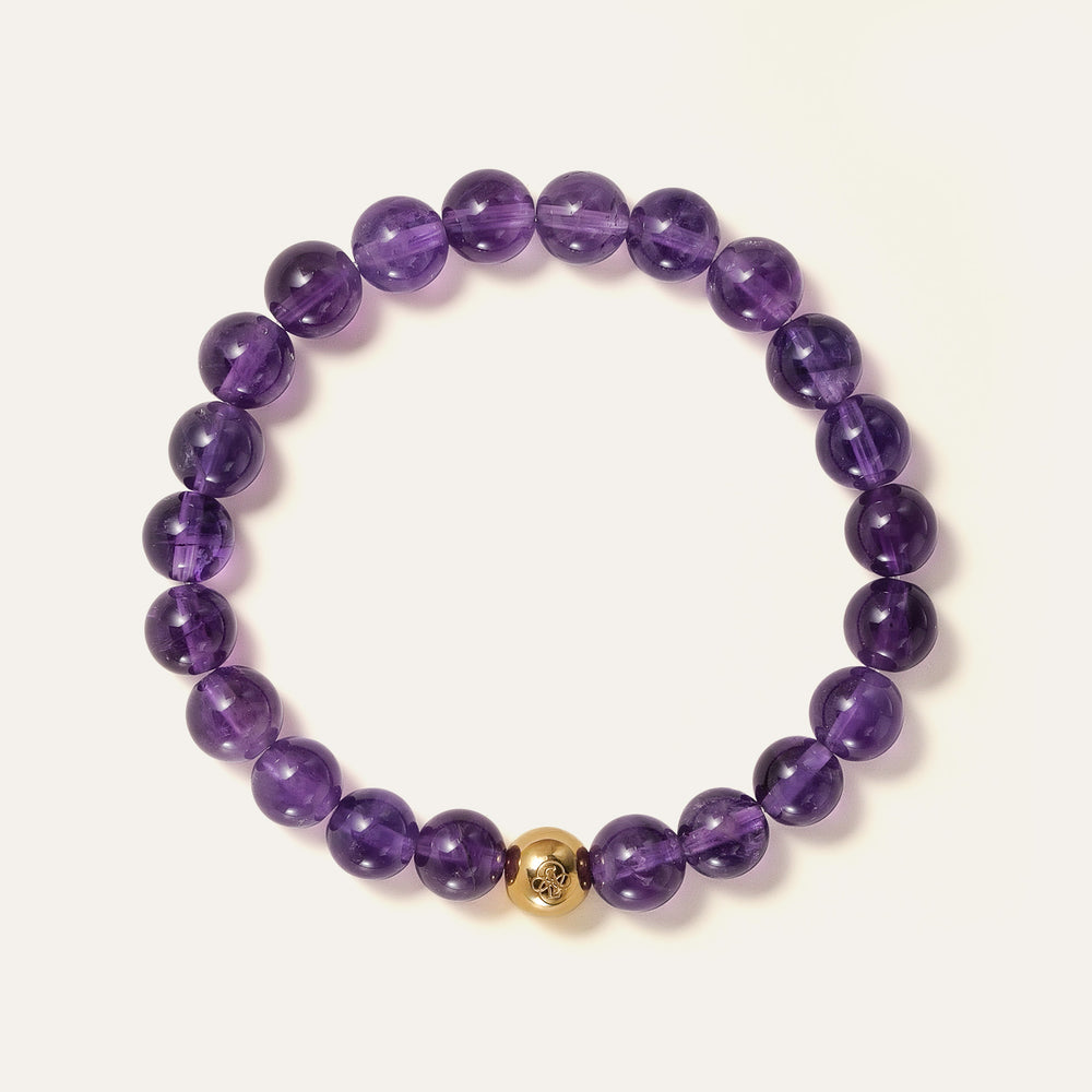 Core Essential bracelet featuring 8mm AA+ natural Brazilian Amethyst beads showcasing deep royal purple hues with the Soul Lykke 14K gold PVD signature bead. This is a natural gemstone and healing crystal bracelet by Soul Lykke.