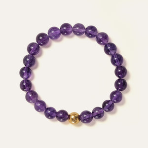 Core Essential bracelet featuring 8mm AA+ natural Brazilian Amethyst beads showcasing deep royal purple hues with the Soul Lykke 14K gold PVD signature bead. This is a natural gemstone and healing crystal bracelet by Soul Lykke.