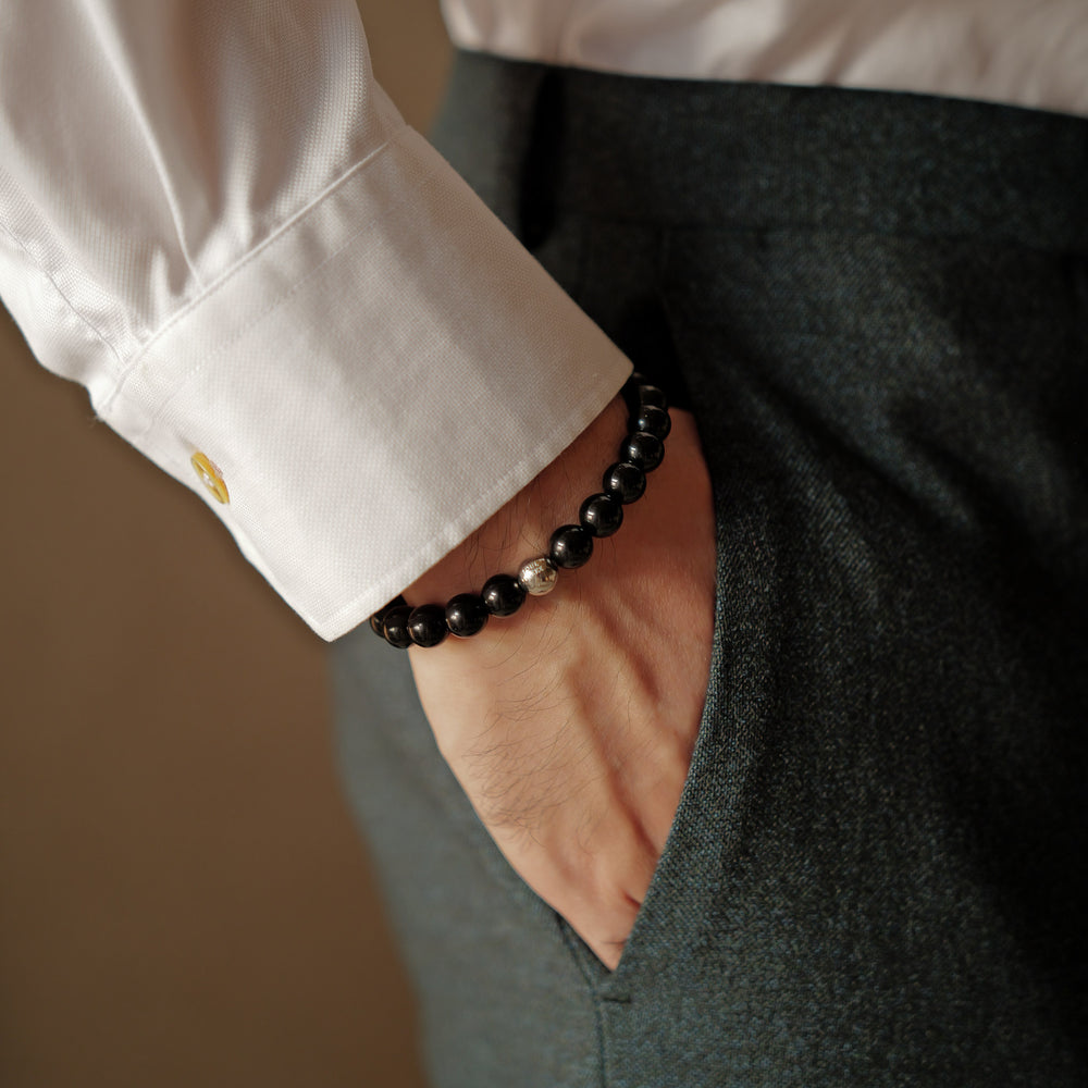 The Core Essential bracelet by Soul Lykke, featuring 8mm natural AAA black obsidian ethically sourced from Mexico, paired with a single hypoallergenic white gold PVD surgical steel signature bead. This is a natural gemstone and healing crystal bracelet by Soul Lykke.