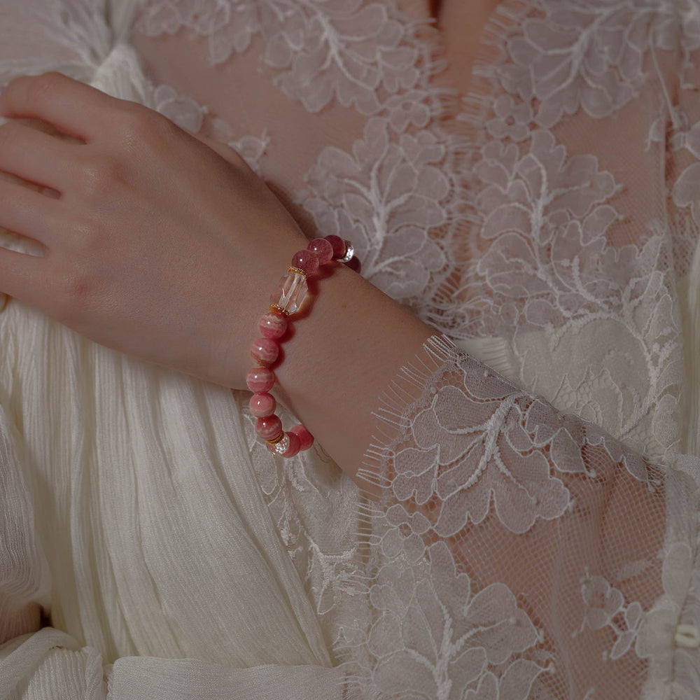 Elegant beaded bracelet combining 8mm natural Lace Rhodochrosite, Star Strawberry Quartz, and a faceted Clear Quartz centerpiece, featuring the Soul Lykke signature gold bead. This is a natural gemstone and healing crystal bracelet by Soul Lykke.