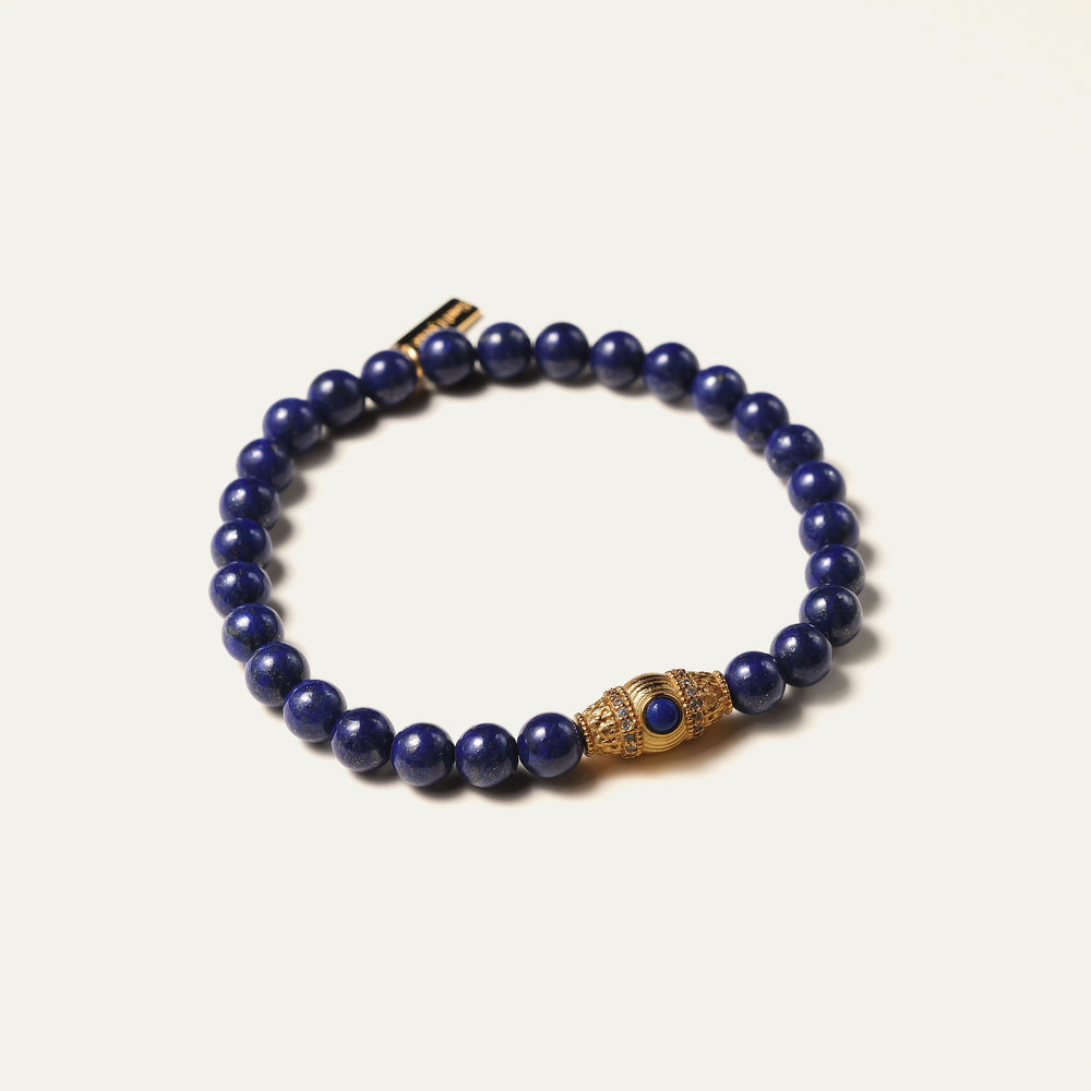 The Royal Vesper bracelet by Soul Lykke, featuring 6mm AAA-grade natural Afghan Lapis Lazuli. This luxury crystal jewelry showcases deep royal blue stones with golden pyrite flakes and an intricate pavé CZ gold barrel bead. This is a natural gemstone bracelet by Soul Lykke.