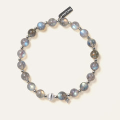 Top-down view of the Soul Lykke Inner Universe bracelet, featuring 6.5-7mm natural AAA-grade Madagascar Labradorite with vivid spectral flashes, accented by 925 sterling silver hardware and a white gold PVD surgical steel tag. This is a natural gemstone and healing crystal bracelet by Soul Lykke.