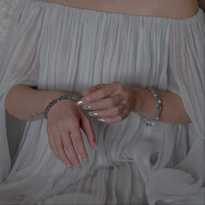 Model wearing the Soul Lykke pure natural Labradorite bracelet with an elegant white pleated dress, showcasing effortless demi-fine jewelry styling.