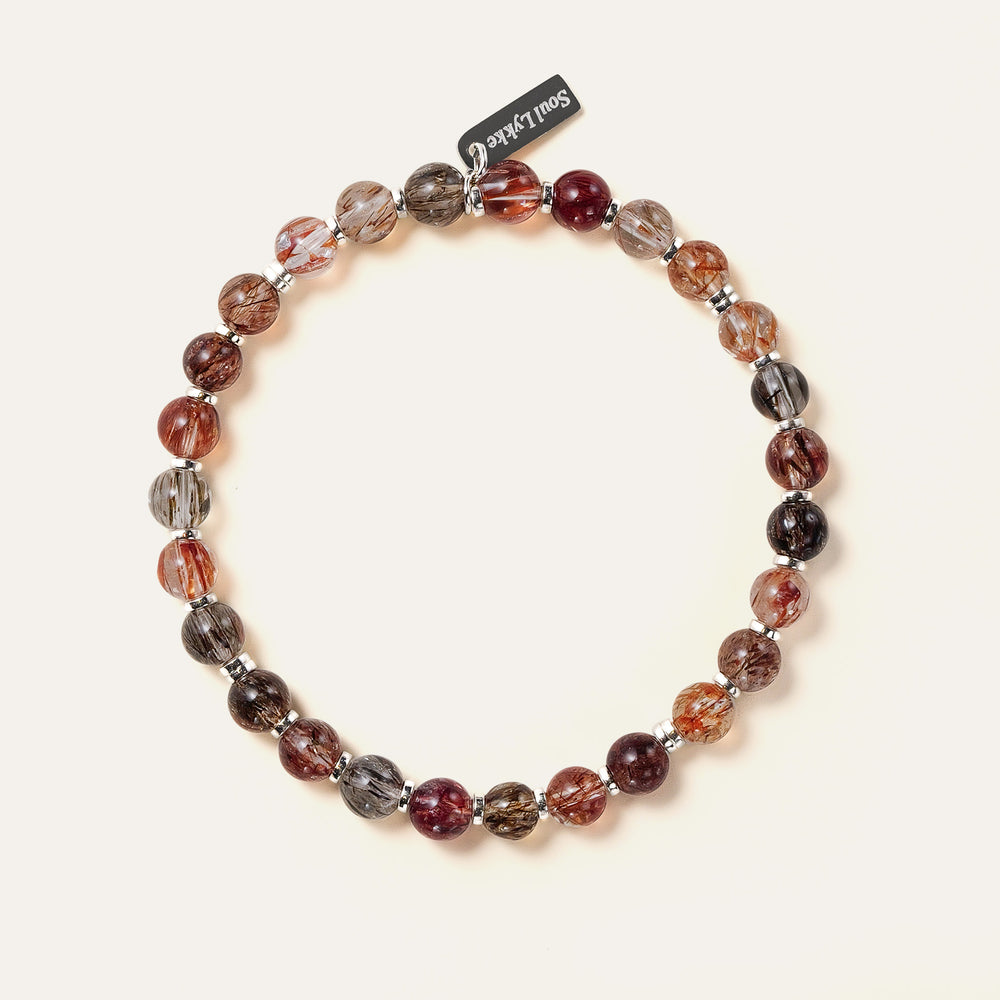 Top-down view of the Soul Lykke Shadow Gold bracelet, featuring glass-clear 6mm AAA+ Black Gold Super Seven beads and a White Gold tag. This is a natural gemstone and healing crystal bracelet by Soul Lykke.