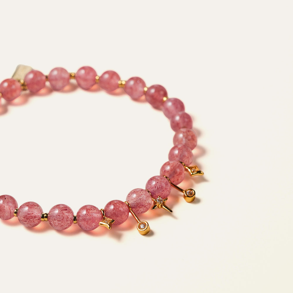 Natural rose-pink Star Strawberry Quartz beaded bracelet featuring gold-plated star charms and the engraved Soul Lykke signature tag. This is a natural gemstone and healing crystal bracelet by Soul Lykke.