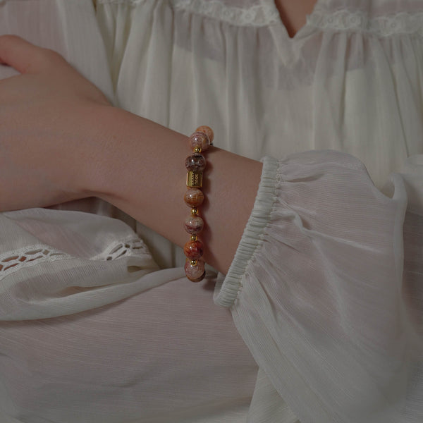 The Terra Nova natural multi-color Phantom Quartz bracelet worn elegantly on the wrist against white fabric.