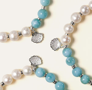 Artisan stacking bracelets featuring The Marine Tear with Dominican Larimar, freshwater pearls, and an engraved Soul Lykke tag, capturing tropical elegance and calmness.