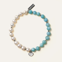 Top view of The Marine Tear artisan bracelet by Soul Lykke, featuring a half-and-half design of 6mm AA grade Dominican Larimar and natural freshwater pearls with a silver seashell charm. This is a natural gemstone and healing crystal bracelet by Soul Lykke.